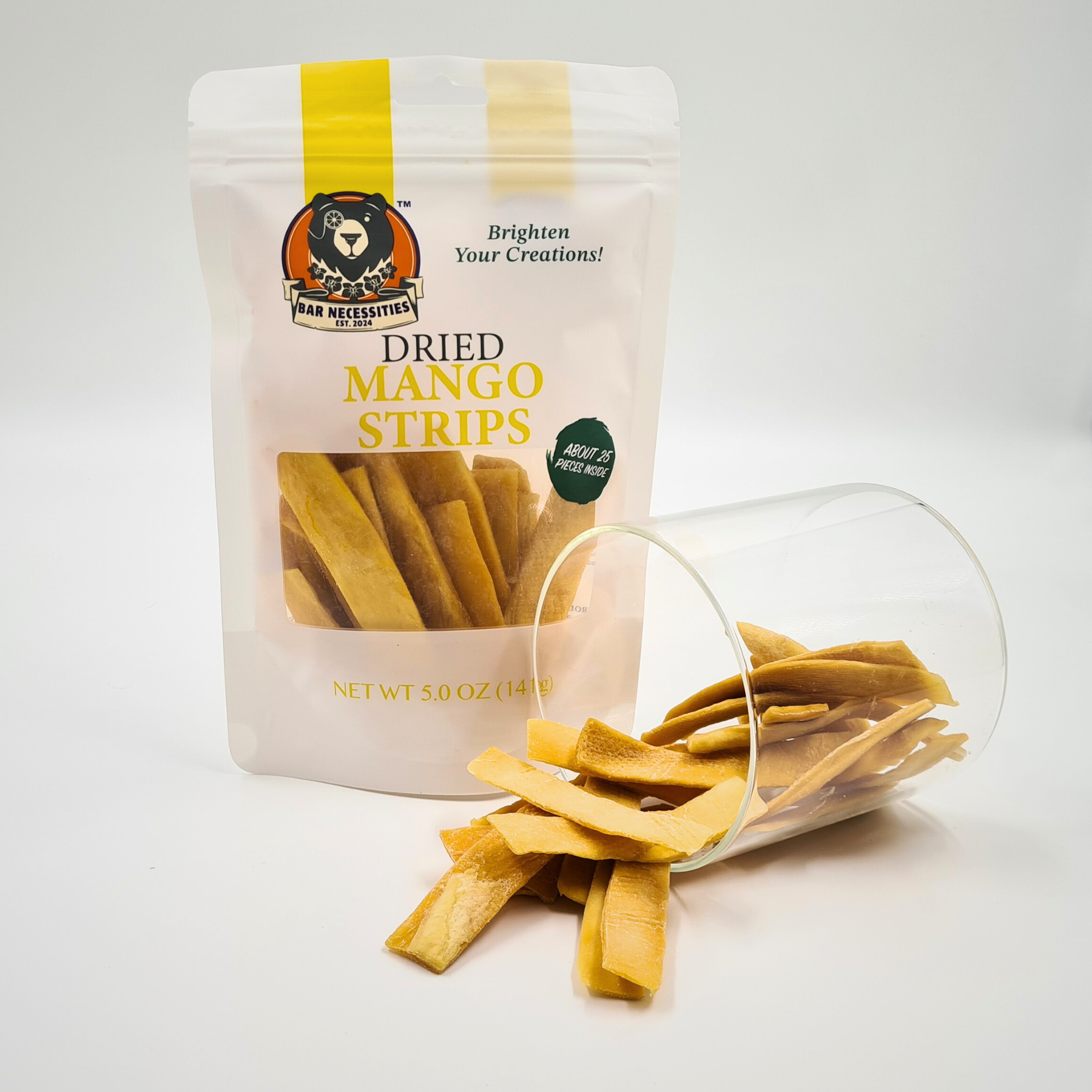 Bar Necessities dried mango strips – resealable 5 oz bag with sweet golden mango slices spilling from a clear cup. Perfect for tropical snacks, cocktail garnishes, charcuterie boards, and fruit gift boxes