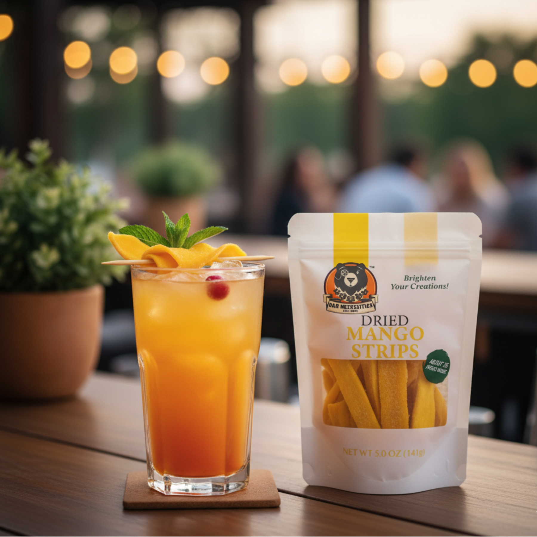 Glass of orange juice with mango slices and a packet of dried mango strips on a table.