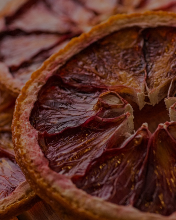 Close-up of dried blood orange cocktail garnishes on wooden table — premium citrus slices for mixology and home bars
