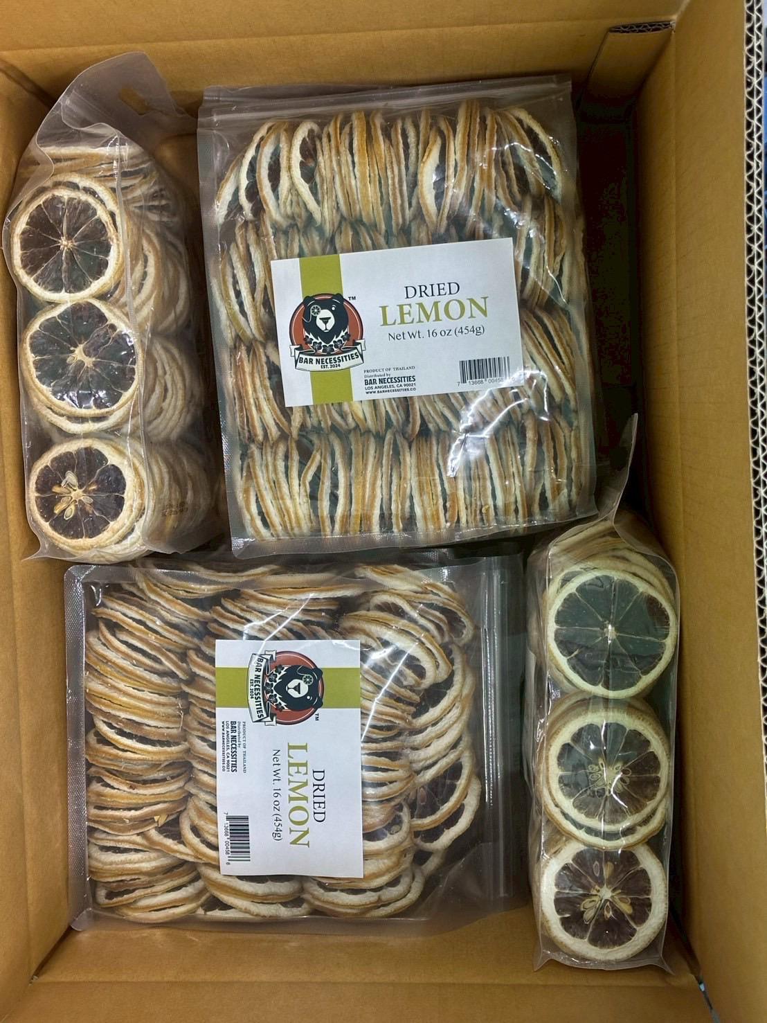 Box containing packages of dried lemon slices with visible labels.