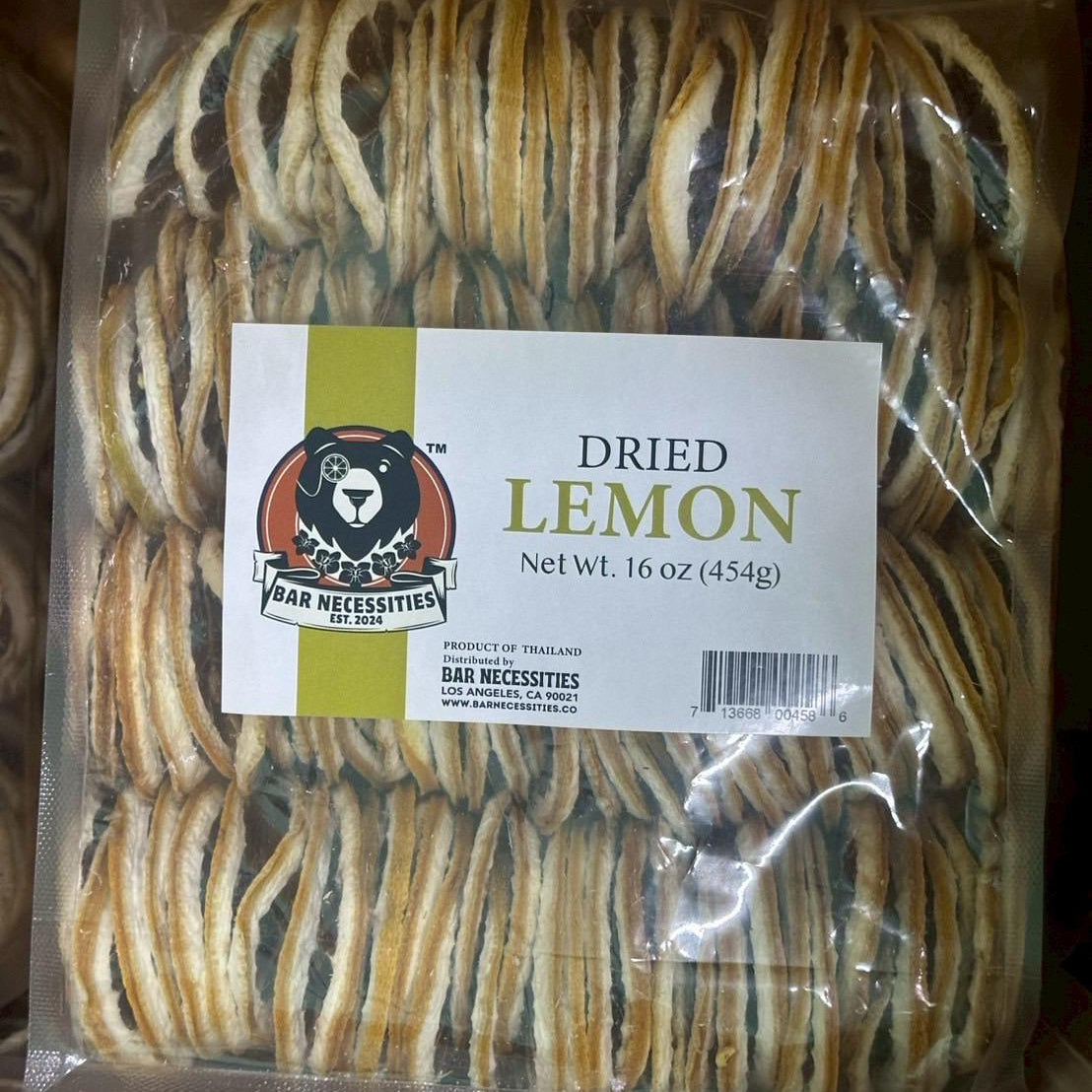 Packaged dried lemons with a label on a matching background