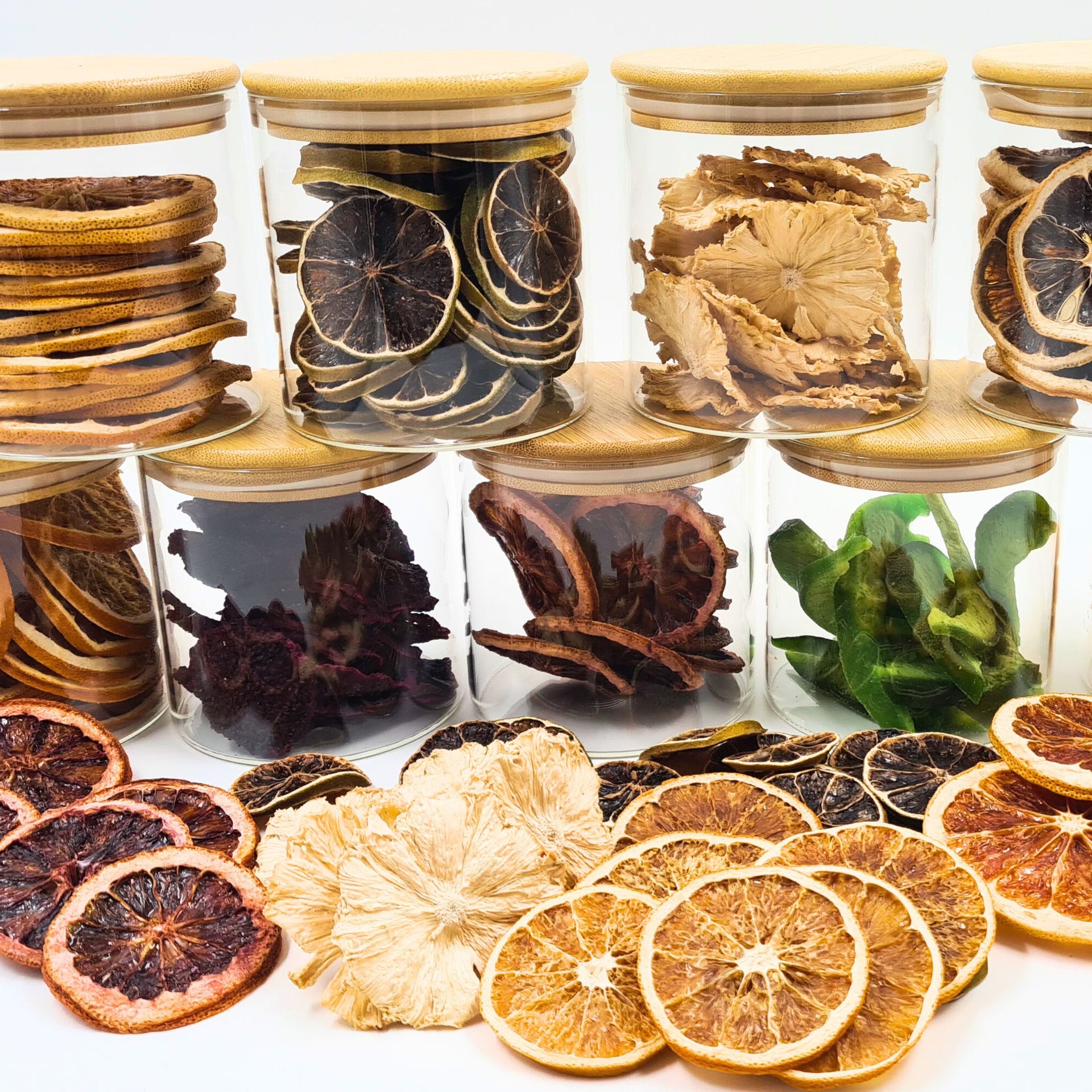 Close-up of cocktail glasses decorated with dried fruit and fresh herb garnishes